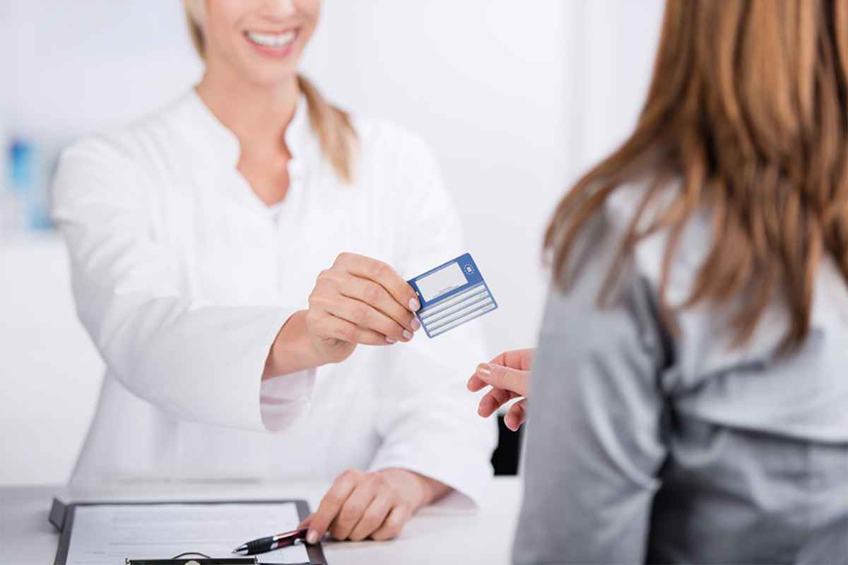 Foto: Patientin und Arzthelferin mit Versicherungskarte 